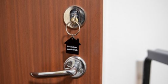 Bild på en dörr med en nyckel i låset.