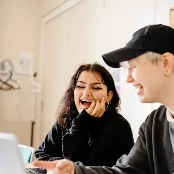 2 personer sitter och skrattar på en kurs