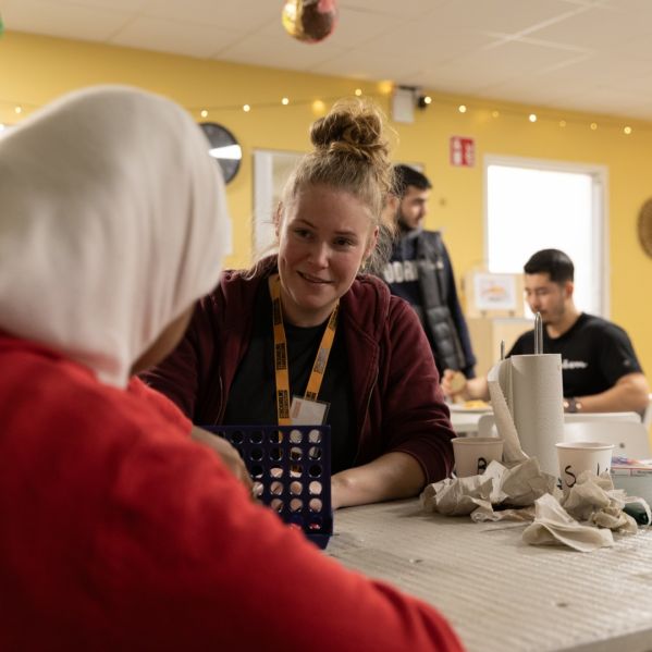 Vägledare och deltagare spelar spel på en av Stockholms Stadsmissions mötesplatser.