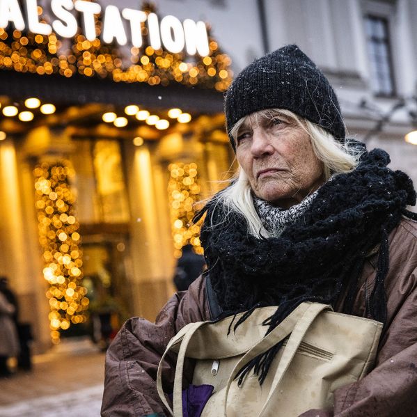 En kvinna står i kylan utanför Centralstationen i Stockholm.