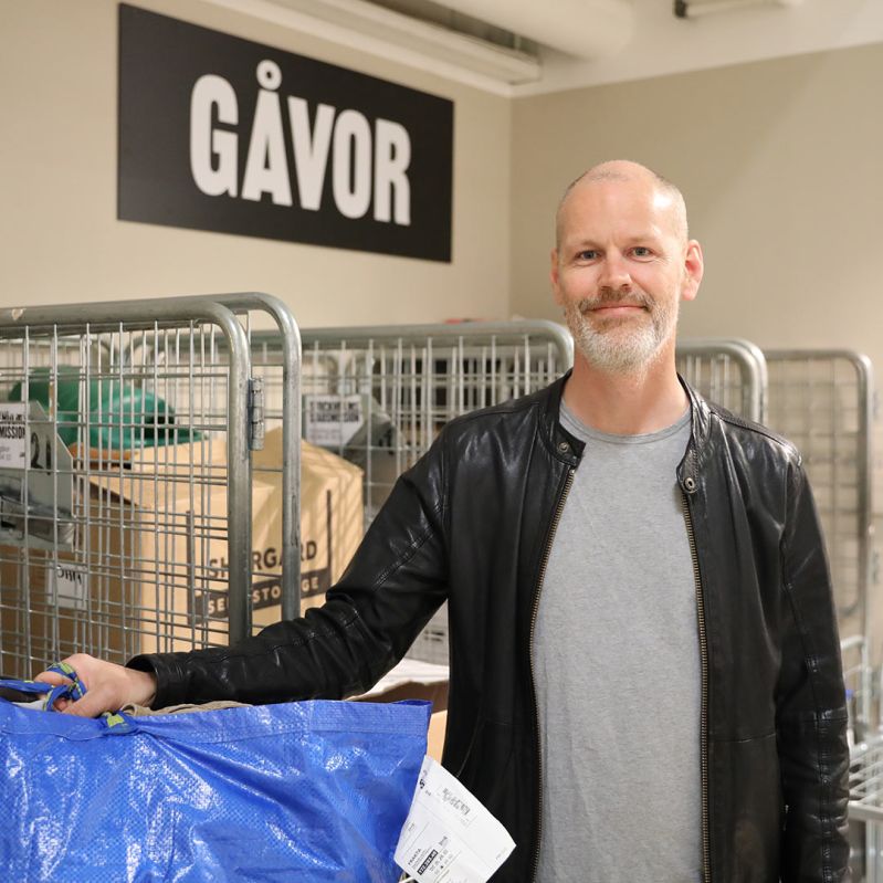 Givare med en kasse kläder i en av Stockholms Stadsmissions second hand-butiker.