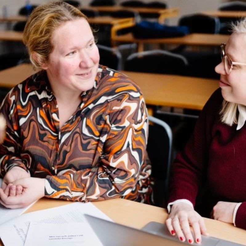  Elever på Stockholms Stadsmissions yrkeshögskola diskuterar vid ett bord.