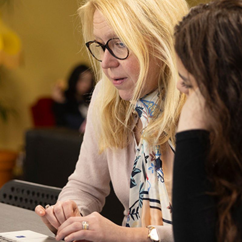 Volontären Marit stöttar en deltagare på en av Stockholms Stadsmissions mötesplatser.