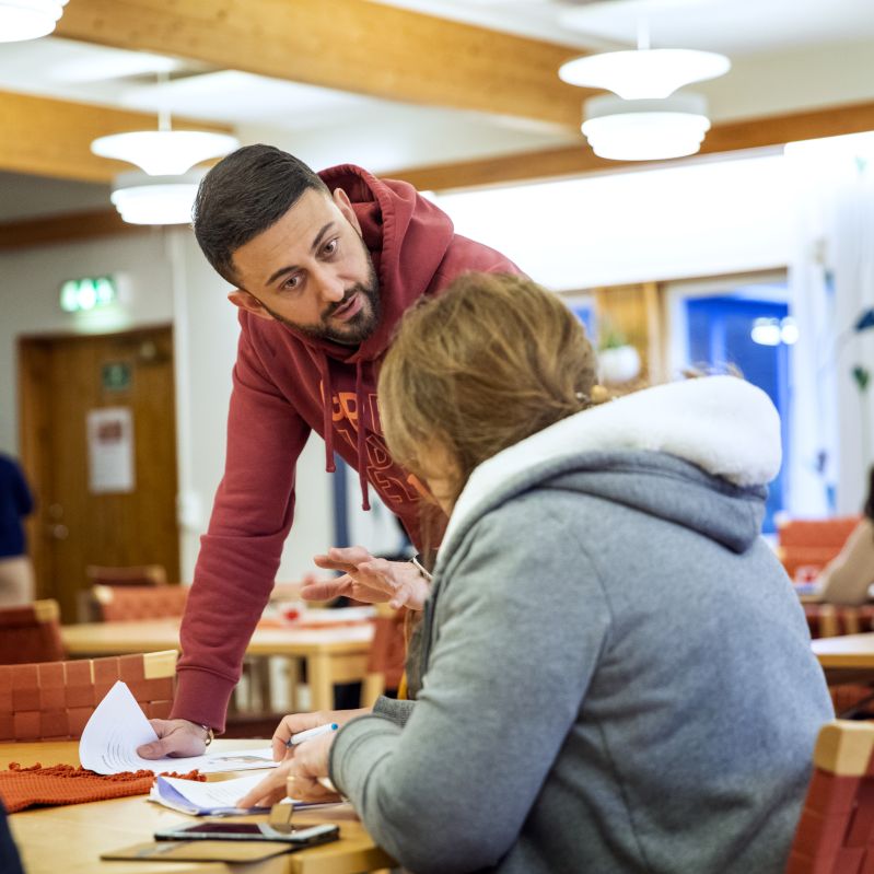 Lärare med elev i skolsal