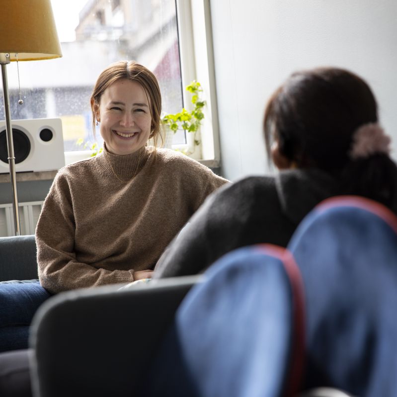 Två tjejer samtalar i en soffa