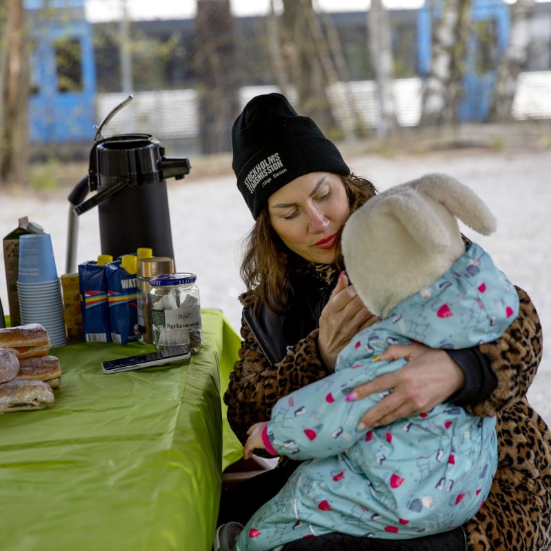 kvinna sitter med barn i knät